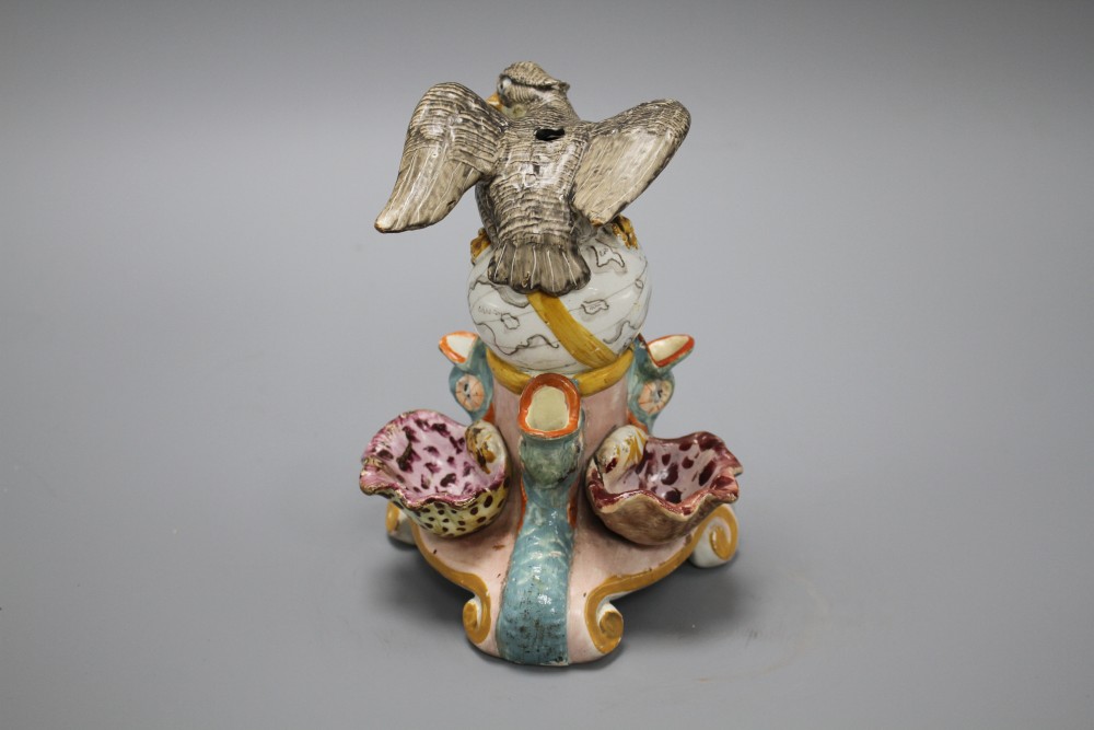 An early 19th century Staffordshire inkwell, modelled with an eagle perched upon a globe above three dolphins and shells, height 15cm